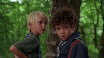 Movie still from “Dennis the Menace” (1993), directed by Nick Castle – Two young boys standing next to each other in the woods; Close Up shot, Low angle