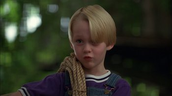 Movie still from “Dennis the Menace” (1993), directed by Nick Castle – A young boy holding a rope around his neck; Close Up shot, Low angle