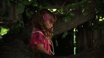 Movie still from “Dennis the Menace” (1993), directed by Nick Castle – A little girl with a flower in her hair; Medium shot, High angle
