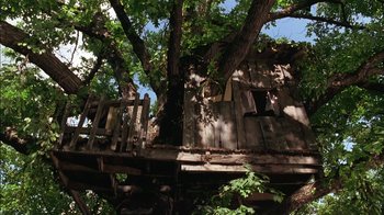 Movie still from “Dennis the Menace” (1993), directed by Nick Castle – An old tree house with a wooden deck; Extreme Wide shot, Low angle