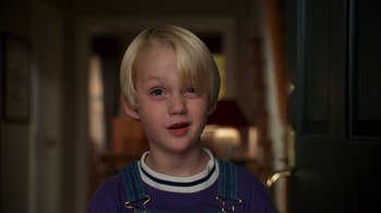 Movie still from “Dennis the Menace” (1993), directed by Nick Castle – A young boy with blonde hair and a blue shirt; Close Up shot, Low angle
