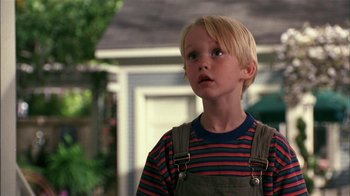 Movie still from “Dennis the Menace” (1993), directed by Nick Castle – A young blond boy wearing a striped shirt and suspenders; Close Up shot, Low angle