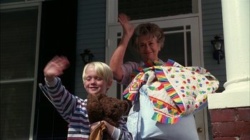 Movie still from “Dennis the Menace” (1993), directed by Nick Castle – A woman and a boy waving at the camera; Medium shot, Low angle