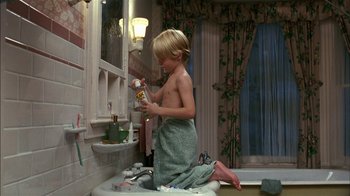 Movie still from “Dennis the Menace” (1993), directed by Nick Castle – A young boy in the bathroom brushing his teeth; Medium shot, High angle