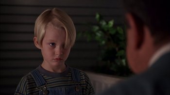 Movie still from “Dennis the Menace” (1993), directed by Nick Castle – A young boy with blonde hair and a striped shirt is looking at a man; Close Up shot, Over the shoulder angle