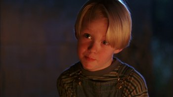 Movie still from “Dennis the Menace” (1993), directed by Nick Castle – A little boy with blonde hair wearing a plaid shirt; Close Up shot, High angle