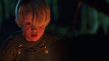 Movie still from “Dennis the Menace” (1993), directed by Nick Castle – A little boy that is standing up in the dark; Close Up shot, Over the shoulder angle