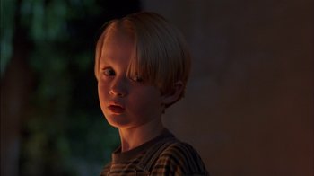 Movie still from “Dennis the Menace” (1993), directed by Nick Castle – A young boy with blonde hair and a striped shirt; Close Up shot, Low angle