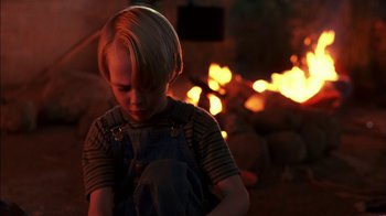 Movie still from “Dennis the Menace” (1993), directed by Nick Castle – A little boy that is standing in front of a fire pit; Close Up shot, Over the shoulder angle