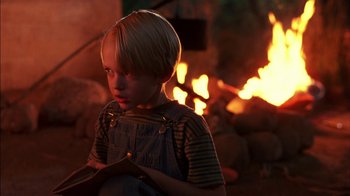 Movie still from “Dennis the Menace” (1993), directed by Nick Castle – A young boy sitting in front of a fireplace; Close Up shot, Over the shoulder angle
