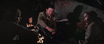 Movie still from “Dersu Uzala” (1975), directed by Akira Kurosawa – A man sitting in front of a fire pit; Medium shot, High angle