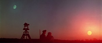 Movie still from “Dersu Uzala” (1975), directed by Akira Kurosawa – Two people standing in front of the setting sun; Extreme Wide shot, Low angle