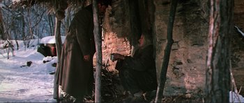 Movie still from “Dersu Uzala” (1975), directed by Akira Kurosawa – A man and a woman are sitting in the woods; Medium shot, High angle