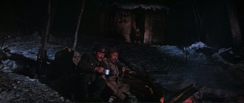 Movie still from “Dersu Uzala” (1975), directed by Akira Kurosawa – A couple of men sitting next to each other on a dirt ground; Wide shot, High angle