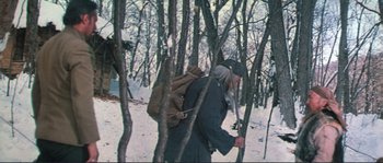 Movie still from “Dersu Uzala” (1975), directed by Akira Kurosawa – A man with a backpack walking through the woods; Wide shot, Low angle