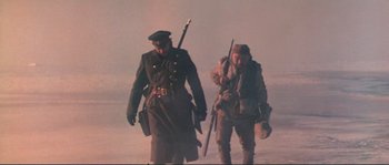 Movie still from “Dersu Uzala” (1975), directed by Akira Kurosawa – Two men in military uniforms walking through the snow; Medium shot, Low angle