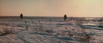 Movie still from “Dersu Uzala” (1975), directed by Akira Kurosawa – A man walking across a snow covered field; Extreme Wide shot, High angle