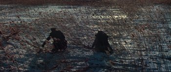 Movie still from “Dersu Uzala” (1975), directed by Akira Kurosawa – A couple of people are playing in the snow; Extreme Wide shot, High angle