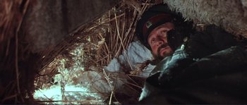 Movie still from “Dersu Uzala” (1975), directed by Akira Kurosawa – A man with a beard and a helmet is in the woods; Close Up shot, Low angle