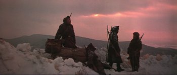 Movie still from “Dersu Uzala” (1975), directed by Akira Kurosawa – Two men in medieval garb standing next to a dead body; Wide shot, Low angle