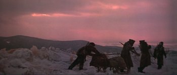 Movie still from “Dersu Uzala” (1975), directed by Akira Kurosawa – A man herding a herd of sheep in the snow; Wide shot, Low angle