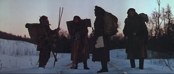 Movie still from “Dersu Uzala” (1975), directed by Akira Kurosawa – A group of people standing in the snow with skis; Wide shot, Low angle