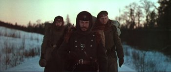 Movie still from “Dersu Uzala” (1975), directed by Akira Kurosawa – A group of men walking in the snow wearing military uniforms; Medium shot, Low angle