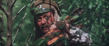 Movie still from “Dersu Uzala” (1975), directed by Akira Kurosawa – A man in a hat is holding a rifle; Close Up shot, High angle