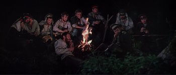 Movie still from “Dersu Uzala” (1975), directed by Akira Kurosawa – A group of people sitting around a fire; Wide shot, High angle