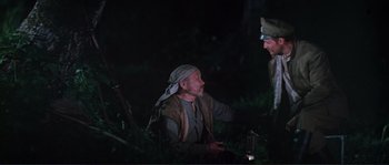 Movie still from “Dersu Uzala” (1975), directed by Akira Kurosawa – Two men are talking in the woods at night; Medium shot, High angle