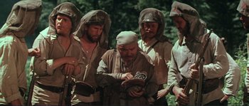 Movie still from “Dersu Uzala” (1975), directed by Akira Kurosawa – A group of men standing next to each other in a forest; Medium shot, High angle