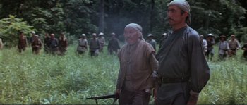 Movie still from “Dersu Uzala” (1975), directed by Akira Kurosawa – A group of men standing in the grass; Medium shot, Low angle