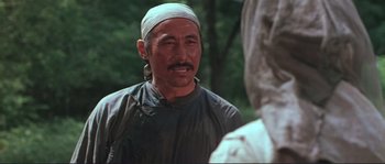 Movie still from “Dersu Uzala” (1975), directed by Akira Kurosawa – An older man wearing a head scarf and a gray shirt; Close Up shot, Over the shoulder angle