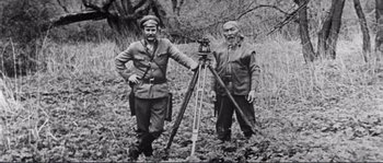 Movie still from “Dersu Uzala” (1975), directed by Akira Kurosawa – Two men standing next to each other in a field; Medium shot, High angle