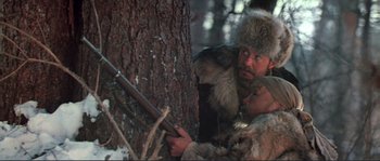 Movie still from “Dersu Uzala” (1975), directed by Akira Kurosawa – A man and a woman in a fur hat and fur coats; Medium shot, Low angle
