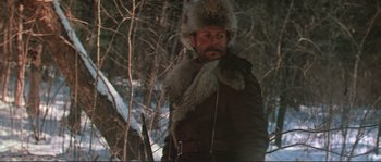 Movie still from “Dersu Uzala” (1975), directed by Akira Kurosawa – A man with a beard and a fur hat in the woods; Medium shot, Low angle