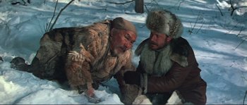 Movie still from “Dersu Uzala” (1975), directed by Akira Kurosawa – Two men in fur coats and fur hats in the snow; Medium shot, High angle
