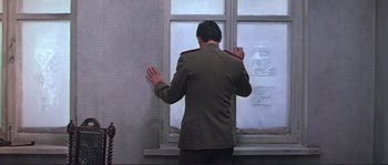 Movie still from “Dersu Uzala” (1975), directed by Akira Kurosawa – A man in a military uniform standing in front of a window; Medium shot, Low angle