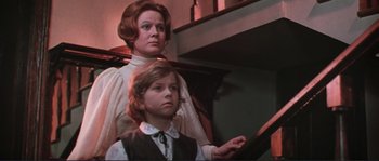 Movie still from “Dersu Uzala” (1975), directed by Akira Kurosawa – A woman and a boy standing next to each other in a room; Medium shot, Low angle