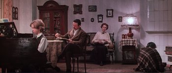 Movie still from “Dersu Uzala” (1975), directed by Akira Kurosawa – A man and a woman sitting in a living room; Wide shot, High angle