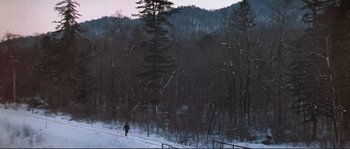 Movie still from “Dersu Uzala” (1975), directed by Akira Kurosawa – A person is skiing down a snowy slope; Extreme Wide shot, High angle