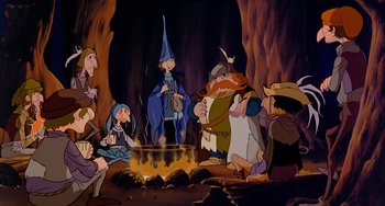 Movie still from “The Last Unicorn” (1982), directed by Jules Bass – A group of people gathered around a fire pit; Wide shot, High angle
