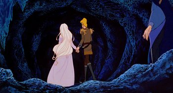 Movie still from “The Last Unicorn” (1982), directed by Jules Bass – A man and a woman holding hands in a cave; Wide shot, Low angle
