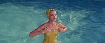 Movie still from “Designing Woman” (1957), directed by Vincente Minnelli – A woman in a yellow bathing suit in the water; Medium shot, High angle