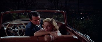 Movie still from “Designing Woman” (1957), directed by Vincente Minnelli – A man and a woman sitting in the back seat of a car; Medium shot, Low angle
