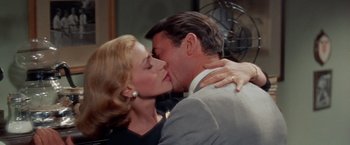 Movie still from “Designing Woman” (1957), directed by Vincente Minnelli – A man and a woman are kissing in a room; Close Up shot, Low angle