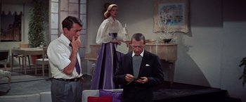 Movie still from “Designing Woman” (1957), directed by Vincente Minnelli – A group of people standing in a living room; Medium shot, Low angle