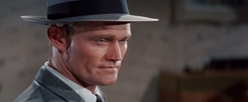 Movie still from “Designing Woman” (1957), directed by Vincente Minnelli – A person wearing a hat and a suit; Close Up shot, Low angle