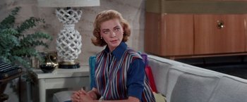 Movie still from “Designing Woman” (1957), directed by Vincente Minnelli – A person sitting on a couch; Medium shot, Over the shoulder angle