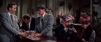Movie still from “Designing Woman” (1957), directed by Vincente Minnelli – A man and a woman wearing hats and suits; Medium shot, Over the shoulder angle